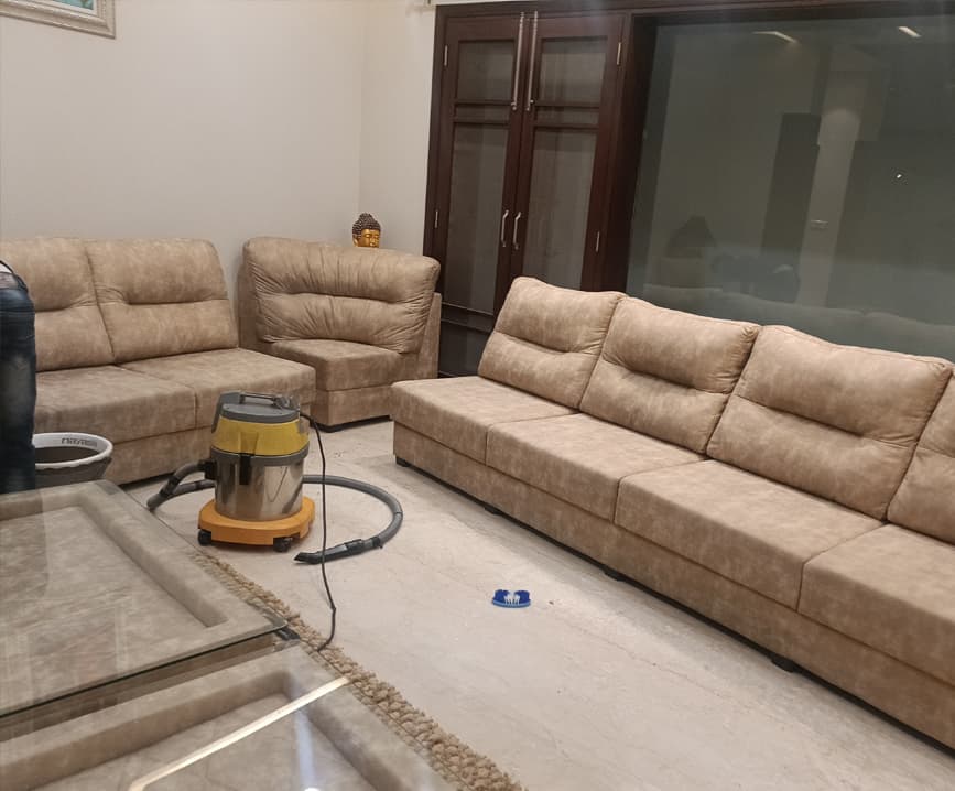 Beige sofa set during on-site sofa cleaning with an extraction machine